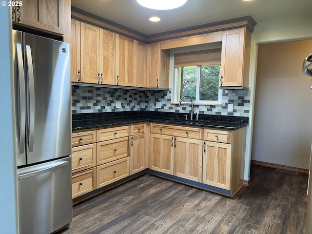 kitchen featuring decorative backsplash, a sink, baseboards, freestanding refrigerator, and dark wood-type flooring