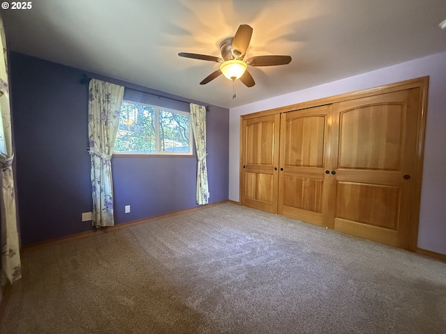 unfurnished bedroom featuring carpet floors, baseboards, ceiling fan, and a closet
