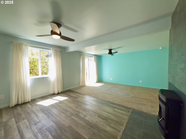 unfurnished living room featuring baseboards, a ceiling fan, wood finished floors, and beamed ceiling