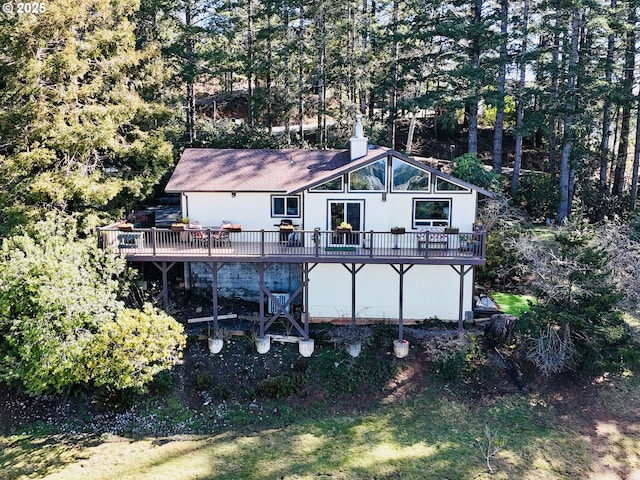 rear view of property with a wooden deck and a chimney