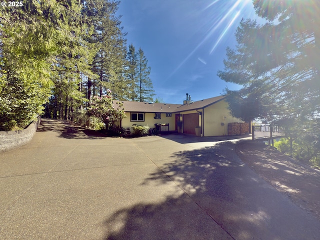 ranch-style house with a garage, a gate, and concrete driveway