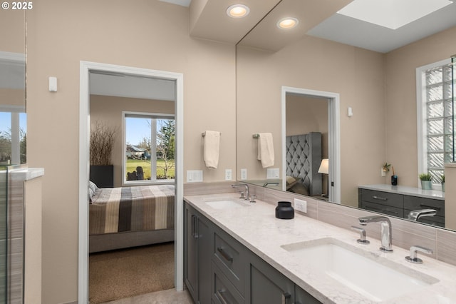 bathroom featuring ensuite bathroom, plenty of natural light, and a sink