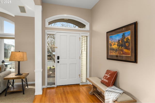 foyer featuring light wood finished floors, visible vents, and baseboards