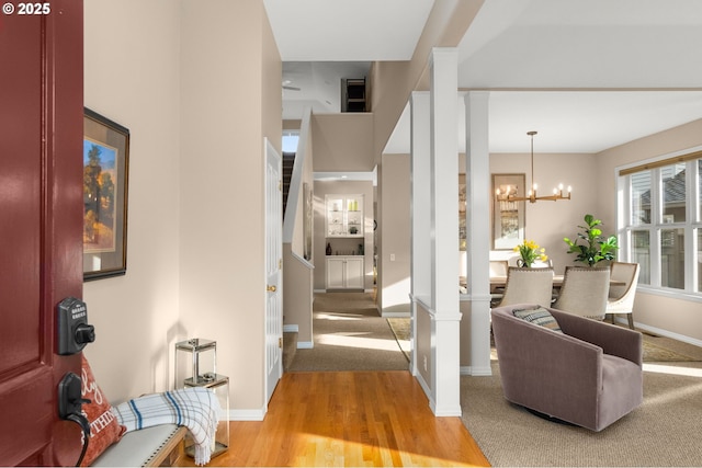 entrance foyer featuring an inviting chandelier, baseboards, and light wood finished floors