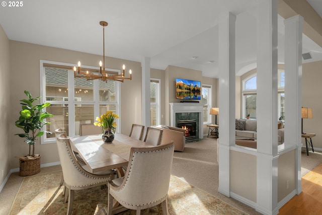 dining room with an inviting chandelier, visible vents, a fireplace, and baseboards