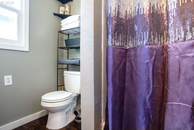 full bathroom with toilet, baseboards, and wood finished floors