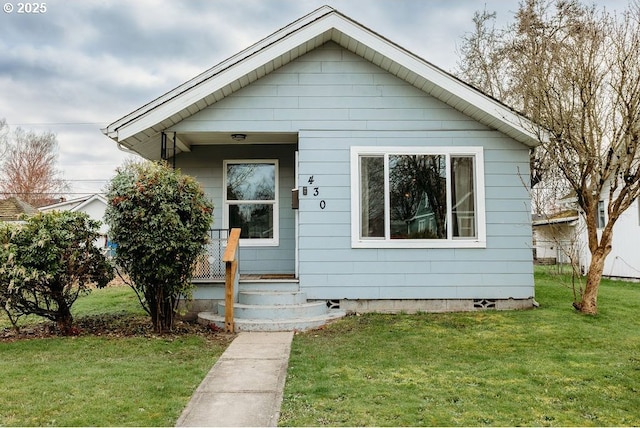 bungalow featuring covered porch and a front lawn