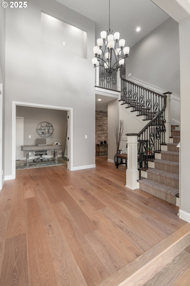 6600 NW Burgundy Dr, Corvallis, OR 97330 - foyer featuring a towering ceiling, wood finished floors, stairs, a chandelier, and baseboards