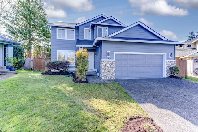 view of front of property with an attached garage, fence, driveway, stone siding, and a front lawn