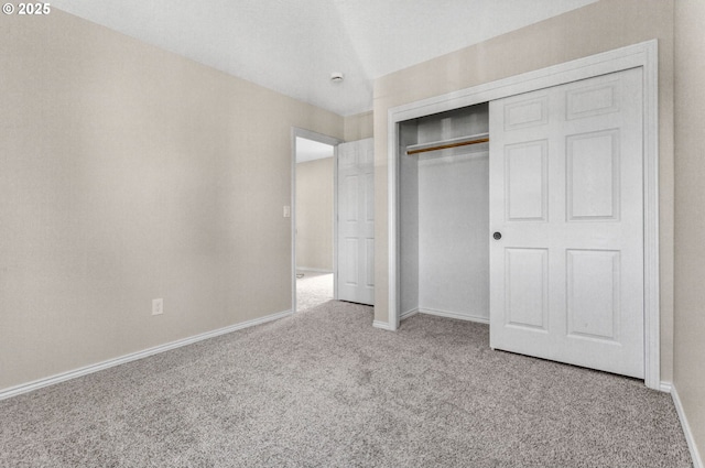 unfurnished bedroom featuring a closet, carpet flooring, and baseboards