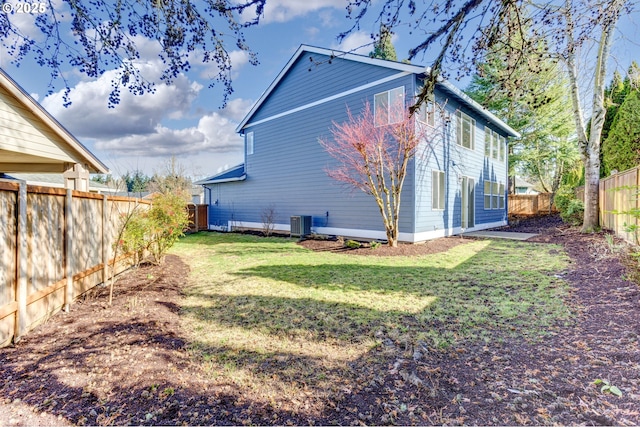 view of side of home featuring a fenced backyard, a yard, and central air condition unit