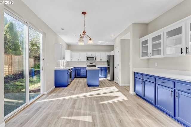 kitchen with stainless steel appliances, light wood-style floors, white cabinetry, and blue cabinets