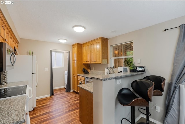 525 SW 207th Ave, Beaverton, OR 97006 - kitchen with appliances with stainless steel finishes, a breakfast bar area, plenty of natural light, and a peninsula