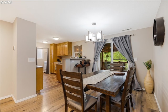 525 SW 207th Ave, Beaverton, OR 97006 - dining area featuring a chandelier, baseboards, and light wood-style flooring