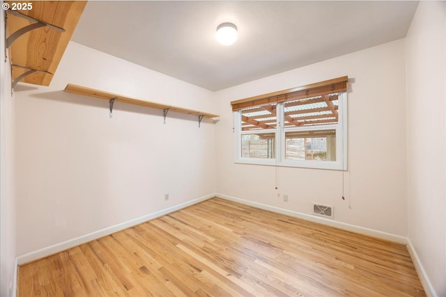 spare room featuring light wood-style flooring, baseboards, and visible vents