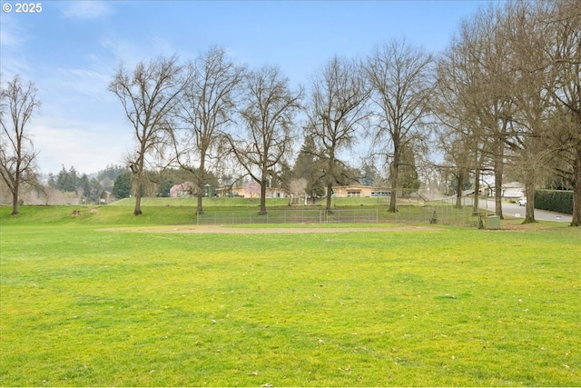 view of property's community with a yard and fence