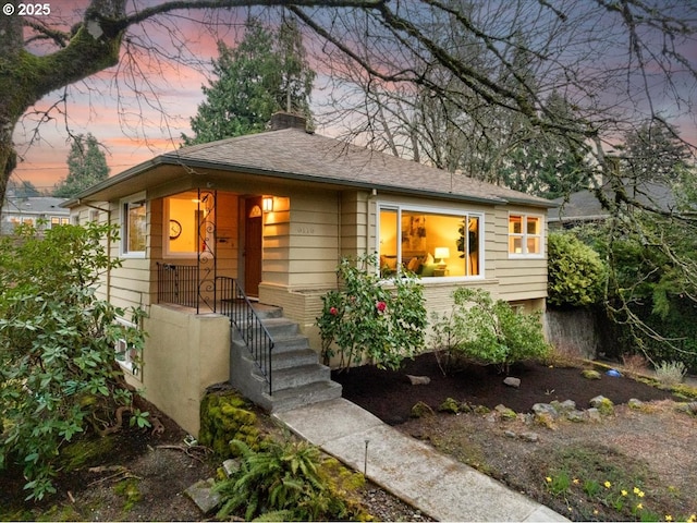 view of front of property with a chimney and a shingled roof