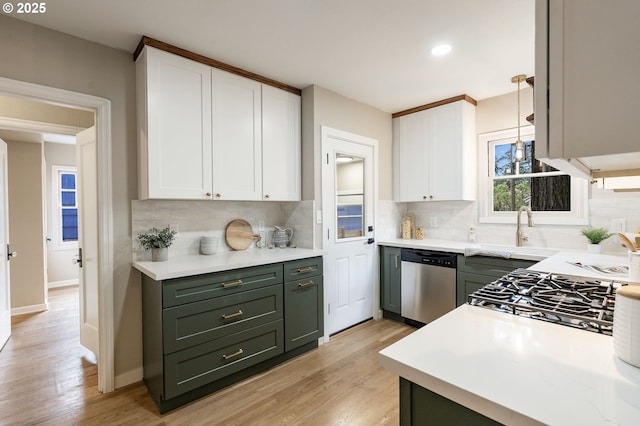 5932 NE 29th Ave, Portland, OR 97211 - kitchen with stainless steel dishwasher, white cabinetry, a sink, light wood-style floors, and recessed lighting
