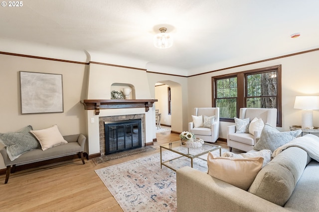 5932 NE 29th Ave, Portland, OR 97211 - living area with arched walkways, light wood-style flooring, baseboards, and a stone fireplace