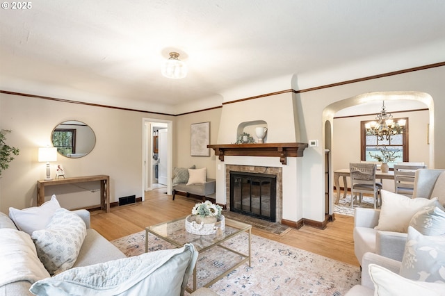 5932 NE 29th Ave, Portland, OR 97211 - living room with a chandelier, arched walkways, wood finished floors, and baseboards