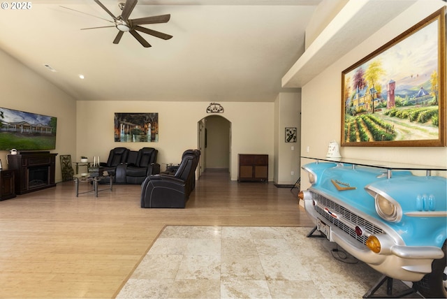 6783 Rogue River Dr, Shady Cove, OR 97539 - living room featuring a ceiling fan, arched walkways, lofted ceiling, and light wood-style flooring