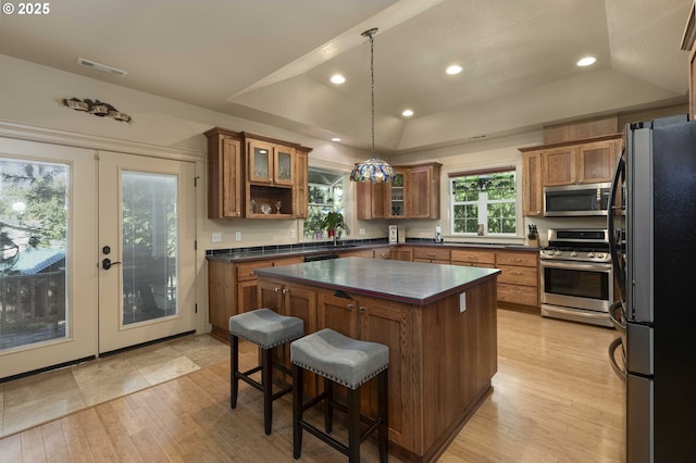 6783 Rogue River Dr, Shady Cove, OR 97539 - kitchen featuring stainless steel appliances, dark countertops, brown cabinetry, a raised ceiling, and recessed lighting