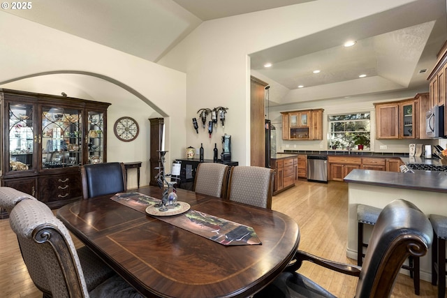 6783 Rogue River Dr, Shady Cove, OR 97539 - dining space with light wood finished floors, arched walkways, recessed lighting, and vaulted ceiling