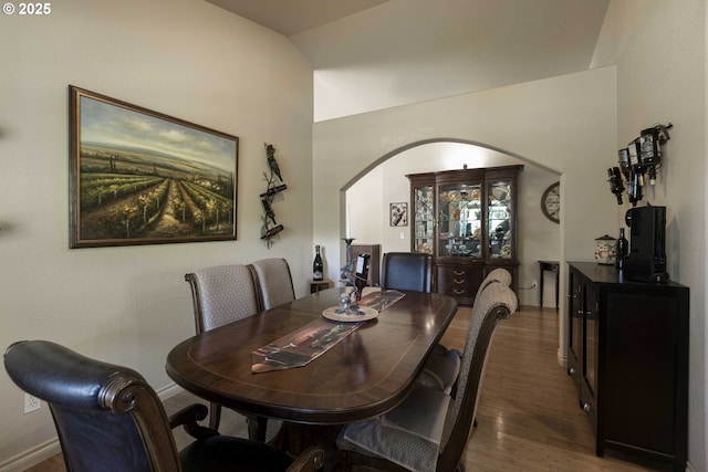 6783 Rogue River Dr, Shady Cove, OR 97539 - dining space featuring arched walkways, wood finished floors, and lofted ceiling