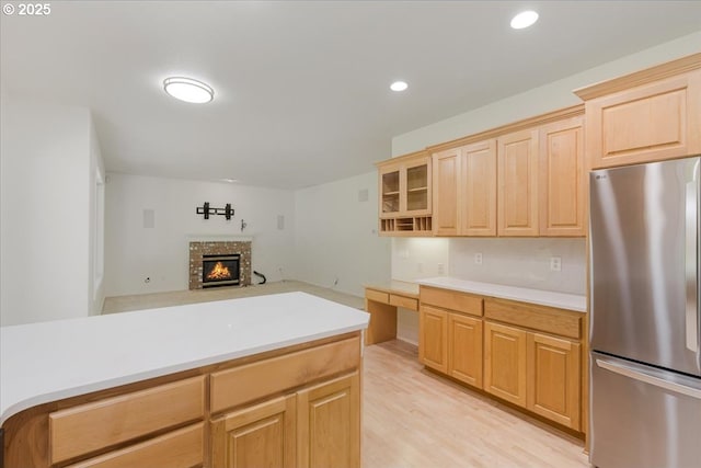 18169 SW Shady Meadow Ct, Beaverton, OR 97007 - kitchen featuring freestanding refrigerator, light brown cabinetry, light countertops, a fireplace, and recessed lighting
