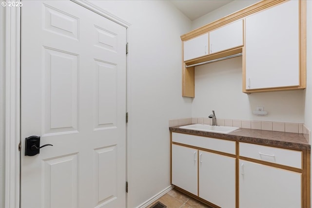 18169 SW Shady Meadow Ct, Beaverton, OR 97007 - kitchen featuring a sink, white cabinets, dark countertops, and baseboards