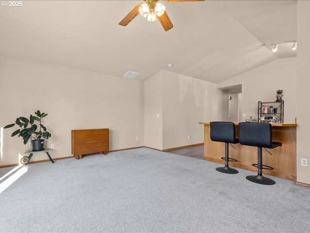 interior space featuring ceiling fan, lofted ceiling, and light carpet