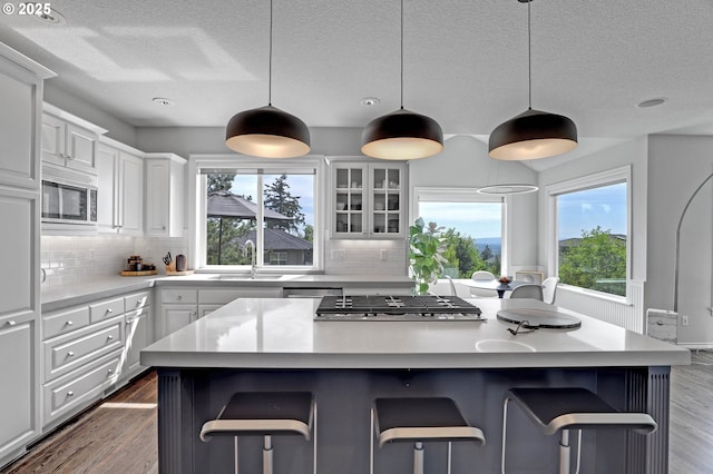 1811 NW Rosefinch Ln, Portland, OR 97229 - kitchen with a sink, appliances with stainless steel finishes, a center island, healthy amount of natural light, and a textured ceiling
