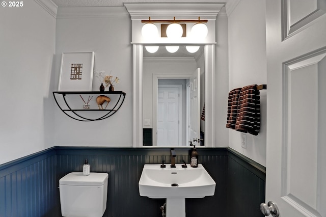 1811 NW Rosefinch Ln, Portland, OR 97229 - half bathroom featuring wainscoting, toilet, crown molding, and a sink