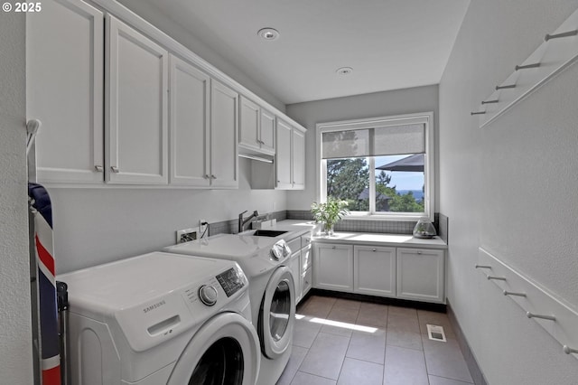 1811 NW Rosefinch Ln, Portland, OR 97229 - laundry room with cabinet space, washer and dryer, and light tile patterned floors