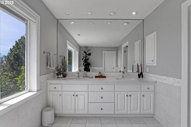 1811 NW Rosefinch Ln, Portland, OR 97229 - full bath with tile walls, plenty of natural light, double vanity, a wainscoted wall, and tile patterned floors