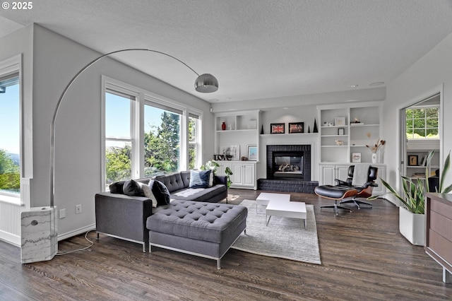 1811 NW Rosefinch Ln, Portland, OR 97229 - living room with a textured ceiling, wood finished floors, built in shelves, and a brick fireplace