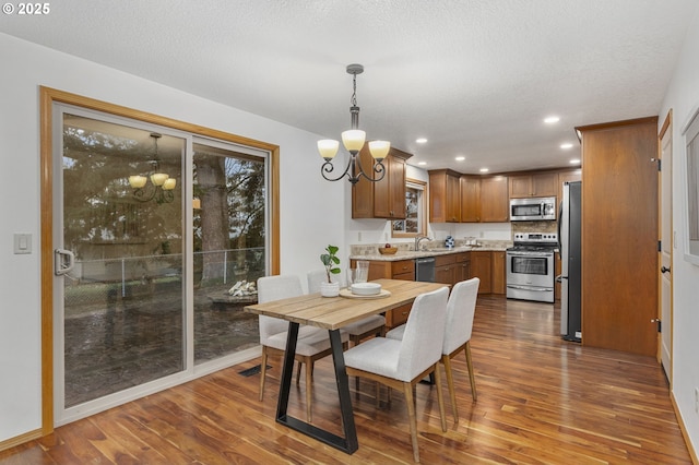 dining area featuring visible vents, dark wood-style flooring, a textured ceiling, a chandelier, and recessed lighting