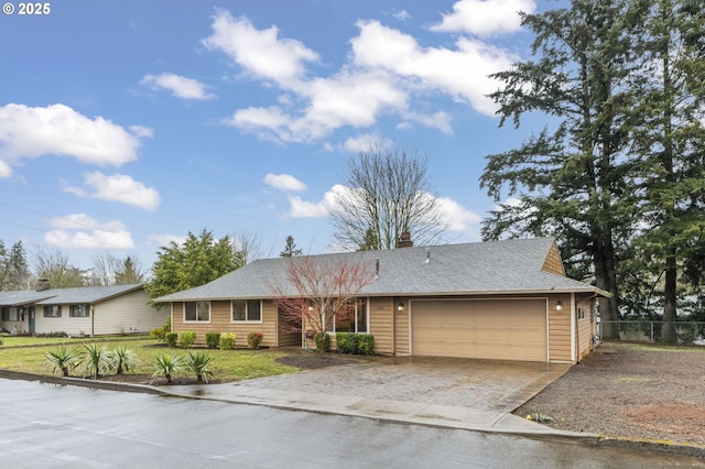 ranch-style house with a shingled roof, an attached garage, a front yard, fence, and driveway