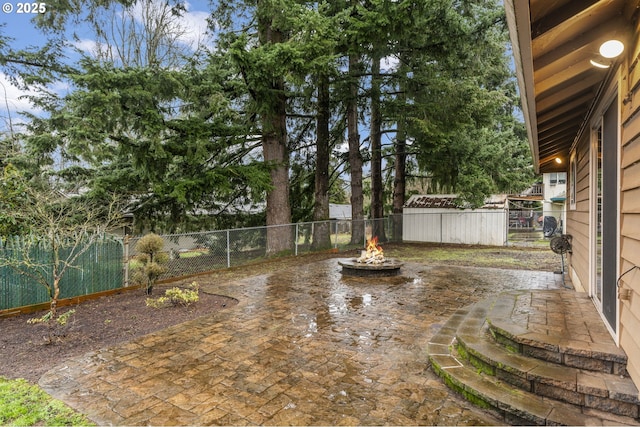 view of yard featuring a fire pit, a patio, and a fenced backyard