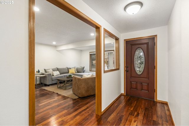 entryway featuring recessed lighting, dark wood finished floors, a textured ceiling, and baseboards