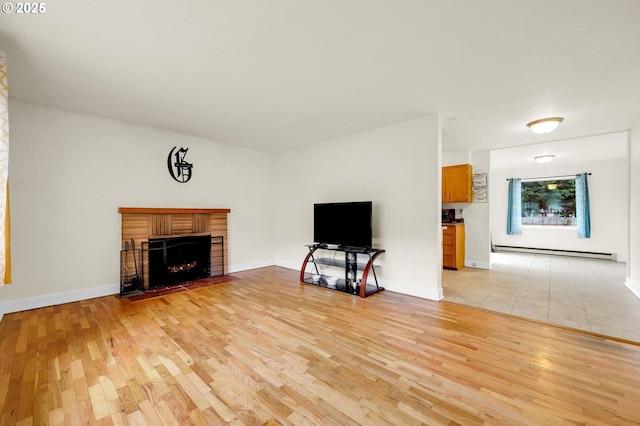 unfurnished living room with baseboards, a brick fireplace, a baseboard radiator, and light wood-style floors