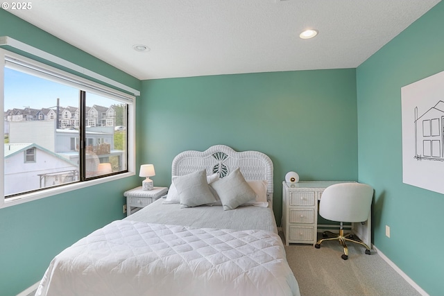 bedroom featuring light colored carpet and a textured ceiling