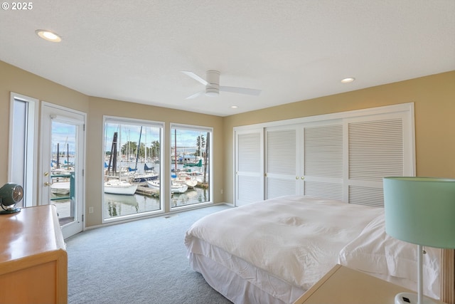 carpeted bedroom featuring ceiling fan, access to exterior, a closet, and a textured ceiling