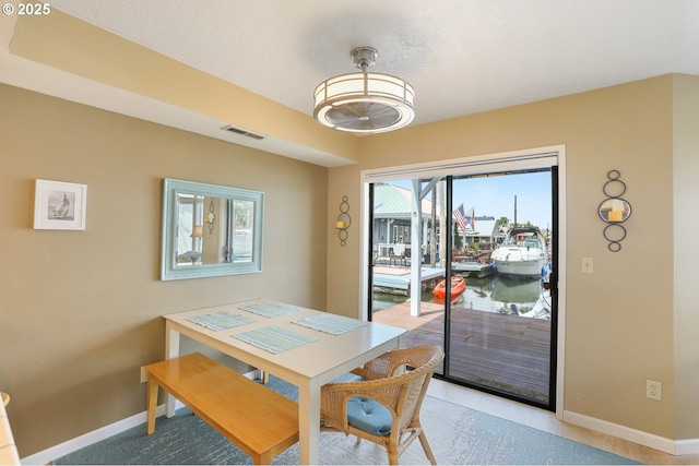 dining space with a textured ceiling and a water view