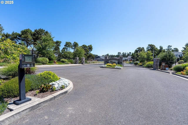 4080 Caddington Ln, Florence, OR 97439 - view of asphalt street with a gate, curbs, and a gated entry