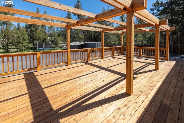16050 Dick Rd, La Pine, OR 97739 - deck featuring a trampoline, a storage unit, a fenced backyard, a pergola, and view of scattered trees