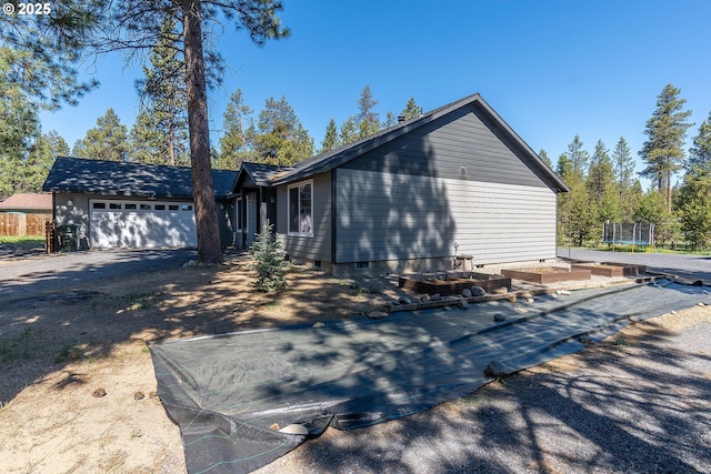 16050 Dick Rd, La Pine, OR 97739 - view of side of property with a trampoline, a garage, crawl space, and driveway