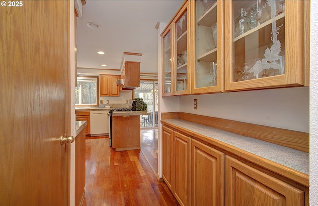 kitchen with glass insert cabinets, light wood-style flooring, recessed lighting, dishwasher, and gas range