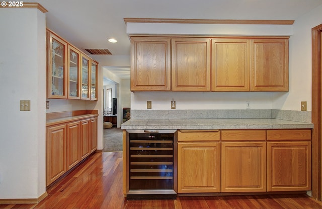 kitchen with visible vents, dark wood finished floors, tile counters, wine cooler, and glass insert cabinets