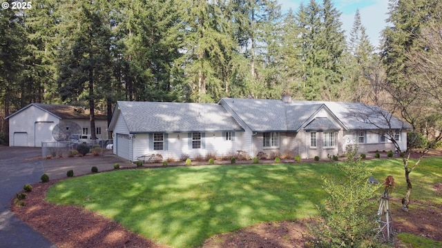 view of front of property with a garage, a chimney, and a front yard